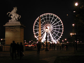 Ferris wheel with onlooking statue.